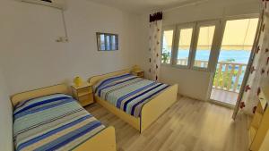 Cet appartement comprend une chambre avec deux lits et un balcon. dans l'établissement Apartments Neda, à Omiš