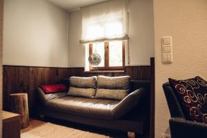 a leather couch in a room with a window at Landgasthof Zehner in Drosendorf