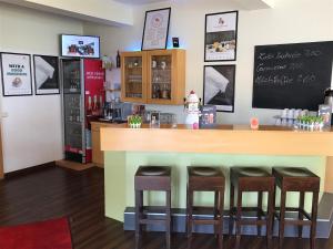 un bar en un restaurante con cuatro taburetes en Good Morning Erfurt, en Erfurt