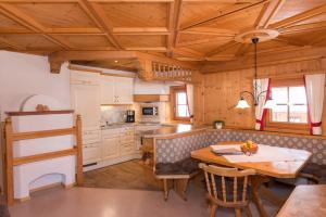 cocina con techo de madera y mesa en Stoffen Zuhaus, en Alpbach