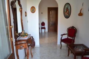 a hallway with chairs and a table and a mirror at la casa di sotto in Alpignano