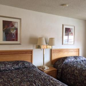 ein Hotelzimmer mit 2 Betten und 2 Lampen in der Unterkunft Economy Inn Alamogordo in Alamogordo