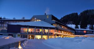 un gran edificio en la nieve por la noche en Rigi Kaltbad Swiss Quality Hotel, en Rigi Kaltbad