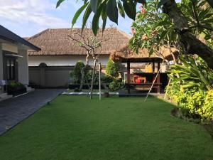 a backyard with a grass yard with a house at The Celuk Homestay in Jimbaran