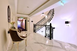 a hallway with a chair and a staircase at Hotel Ziya in Podgorica