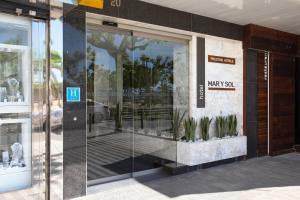 une façade de magasin avec une porte en verre avec des plantes dans l'établissement Prestige Mar y Sol, à Roses