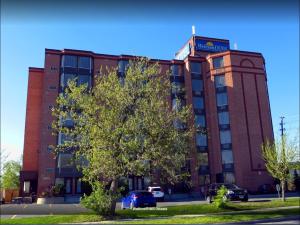 un bâtiment en briques rouges avec un arbre devant lui dans l'établissement WelcomINNS Ottawa, à Ottawa