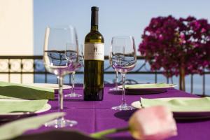 a bottle of wine sitting on a table with two wine glasses at Villa King Apartments in Brela