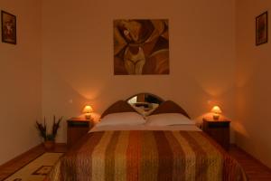 a bedroom with a bed with two lamps and a painting at Pensiunea Kenza in Târgu-Mureş