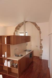 una cucina con lavandino e arco in pietra di Casa do Arco, Santarém a Santarém