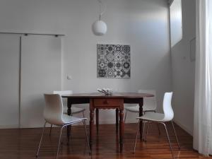 una sala da pranzo con tavolo in legno e sedie bianche di Casa do Arco, Santarém a Santarém