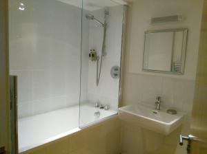 La salle de bains est pourvue d'une douche, d'un lavabo et d'une baignoire. dans l'établissement South Fistral Seaview 2-bed Apartment, à Newquay