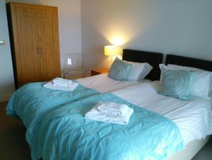 - une chambre d'hôtel avec 2 lits et des serviettes dans l'établissement South Fistral Seaview 2-bed Apartment, à Newquay