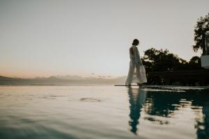 een man op de rand van een lichaam van water bij Pefkaki Boutique Hotel Loutraki in Loutraki