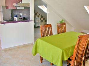 een eetkamer met een groene tafel en stoelen bij Hotel Cap Sud in Saint-Pierre