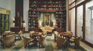 a restaurant with tables and chairs in a room with shelves at The Dharmawangsa Jakarta in Jakarta