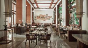 a restaurant with tables and chairs in a room at The Dharmawangsa Jakarta in Jakarta