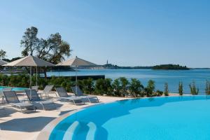 uma piscina com cadeiras e vista para a água em Maistra Camping Amarin Mobile homes em Rovinj