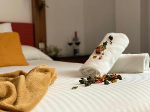 a white bed with towels and flowers on it at Hotel El Bedel in Alcalá de Henares