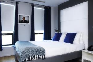 una camera da letto con un grande letto bianco con cuscini blu di The Ridge a New York