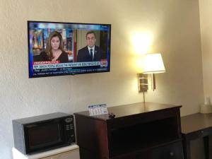 einen Flachbild-TV an der Wand in einem Hotelzimmer in der Unterkunft Economy Inn Alamogordo in Alamogordo