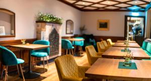 un restaurant avec des tables et des chaises en bois et une cheminée dans l'établissement Hotel Rappen am Münsterplatz, à Fribourg-en-Brisgau