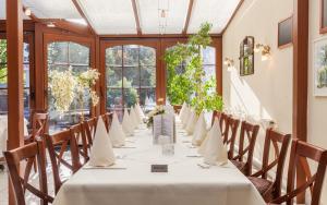 einen langen Tisch in einem Zimmer mit Fenstern in der Unterkunft Hotel Grasberger Hof GmbH in Grasberg