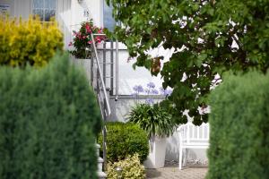 una veranda con panchina bianca e fiori su una casa di Hotel Am See a Baabe