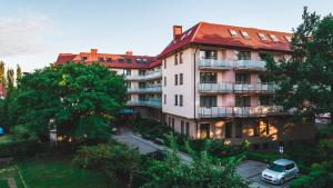 un edificio de apartamentos con un coche aparcado delante de él en Olymp II, en Kołobrzeg