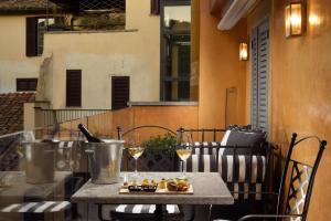 a table on a balcony with a glass of wine at Hotel De' Ricci - Small Luxury Hotels of the World in Rome