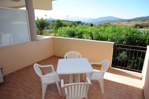 a white table and chairs on a balcony at Lo Smeraldo in Capoliveri