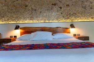 a bedroom with a large bed with white sheets and pillows at Hotel Zamna Boutique in Mérida