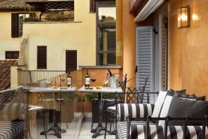 a patio with a table and chairs on a balcony at Hotel De' Ricci - Small Luxury Hotels of the World in Rome