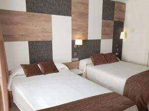 A bed or beds in a room at Hotel Cesar Augustus