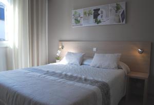 A bed or beds in a room at Logis Hôtel du Midi - Rodez Centre-Ville