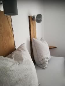 een bed met witte kussens en een lamp erop bij Ferienwohnung Drabinski in Kiel