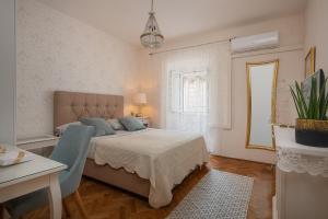 1 dormitorio con cama, mesa y ventana en Apartments & Rooms Perla, en Dubrovnik