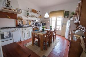 een keuken met een houten tafel en een keuken met witte apparatuur bij Casa do Mar - Nazaré in Nazaré