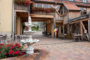 una fuente blanca en un patio con mesas y sillas en Pension-Café-Libelle, en Elxleben bei Arnstadt