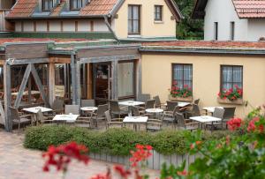 un patio con mesas y sillas frente a un edificio en Pension-Café-Libelle, en Elxleben bei Arnstadt