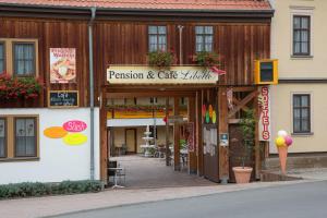 un edificio de madera con un restaurante y una cafetería cocina en Pension-Café-Libelle, en Elxleben bei Arnstadt