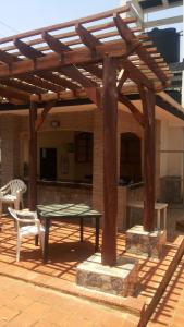 une pergola en bois avec une table et un banc dans l'établissement Victoria Panorama Hotel, à Jinja