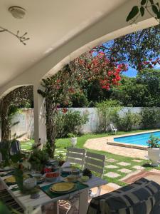 eine Terrasse mit einem Tisch und einem Pool in der Unterkunft Villa Saint Tropez in Cabo Frio