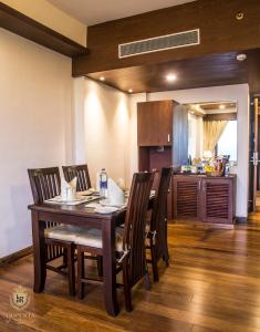 a kitchen and dining room with a table and chairs at KPM TRIPENTA HOTEL in Kozhikode