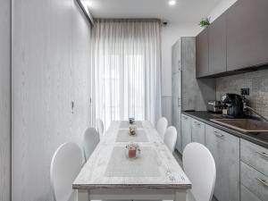 uma cozinha com uma mesa e cadeiras brancas numa cozinha em Diaz Apartment em Cagliari