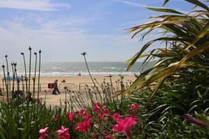 einen Strand mit Menschen, die auf dem Sand und dem Meer wandeln in der Unterkunft The Canford in Poole