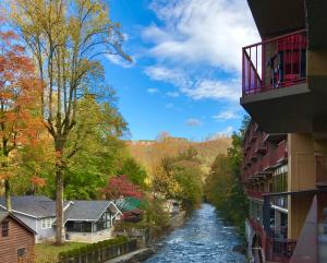 a river in a town with buildings and trees at Baymont by Wyndham Gatlinburg On The River in Gatlinburg