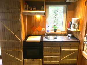 een kleine keuken met een wastafel en een raam bij Norwegisches Holzhaus in Neuruppin