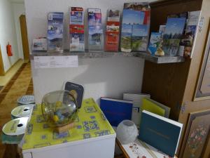 a table with a fish bowl and books on a shelf at Alpenappartement Claudia in Piesendorf