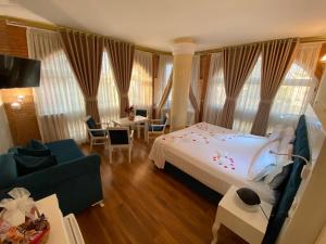 a bedroom with a bed and a living room with a couch at The Red Bricks Hotel in Shkodër